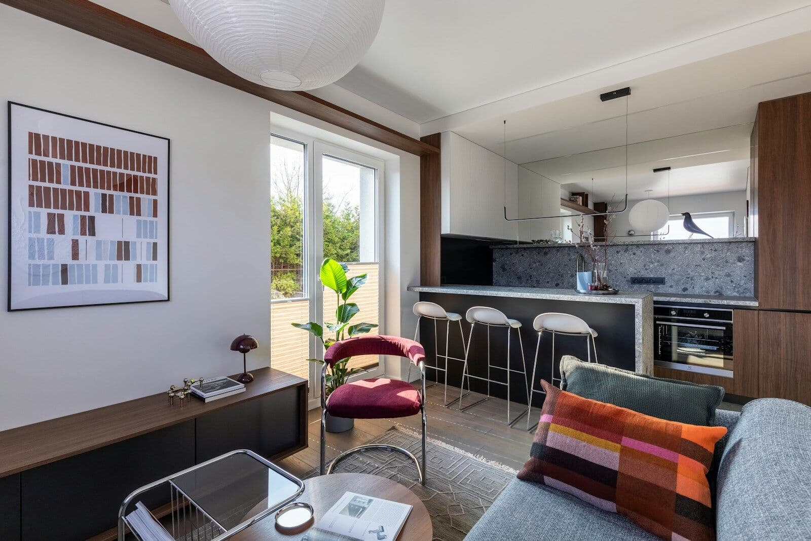 Modern open-plan living room and kitchen with balcony access