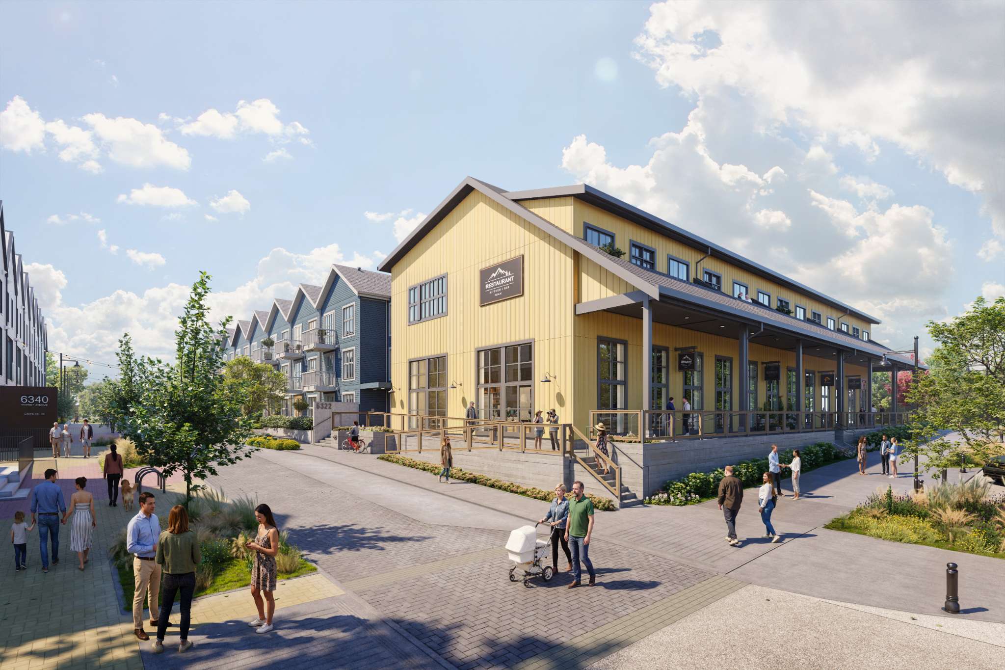 Market Commons – A pedestrian-friendly community streetscape bathed in bright daylight, featuring a large yellow barn-style commercial building with a restaurant patio and a row of blue-sided townhomes in the background. Paved walkways with landscaped greenery are bustling with walking residents, couples, and families under a partly cloudy blue sky.
