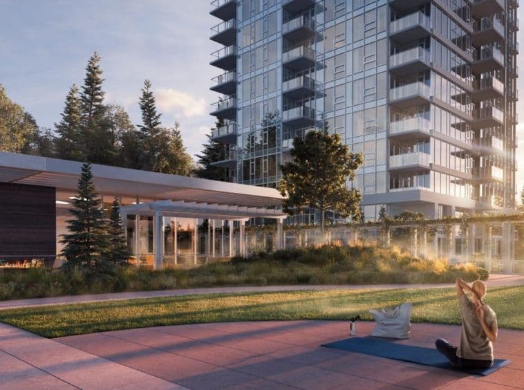 Wynwood Green – Landscaped outdoor courtyard at the base of the towers with a covered lounge structure, pergola, and a woman doing yoga on the lawn.