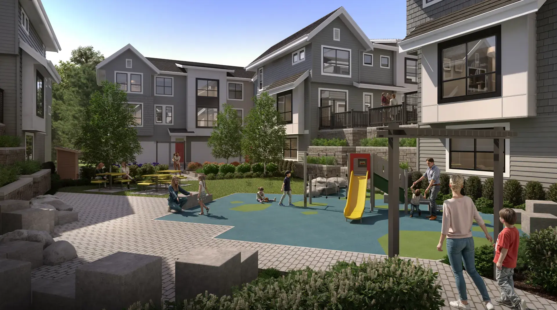 Silverbrook – Shared courtyard playground with a yellow slide and climbing structure, picnic tables, and families with children playing between the townhome buildings.
