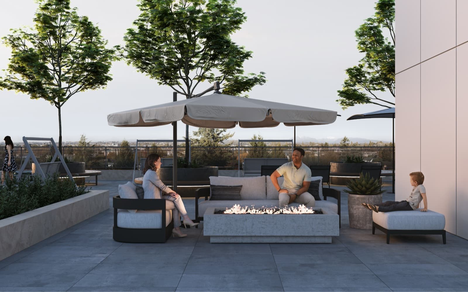 Véra – A rooftop lounge area with outdoor sofas, an umbrella, and a fire table, where two adults and a child are relaxing with a city view in the background.