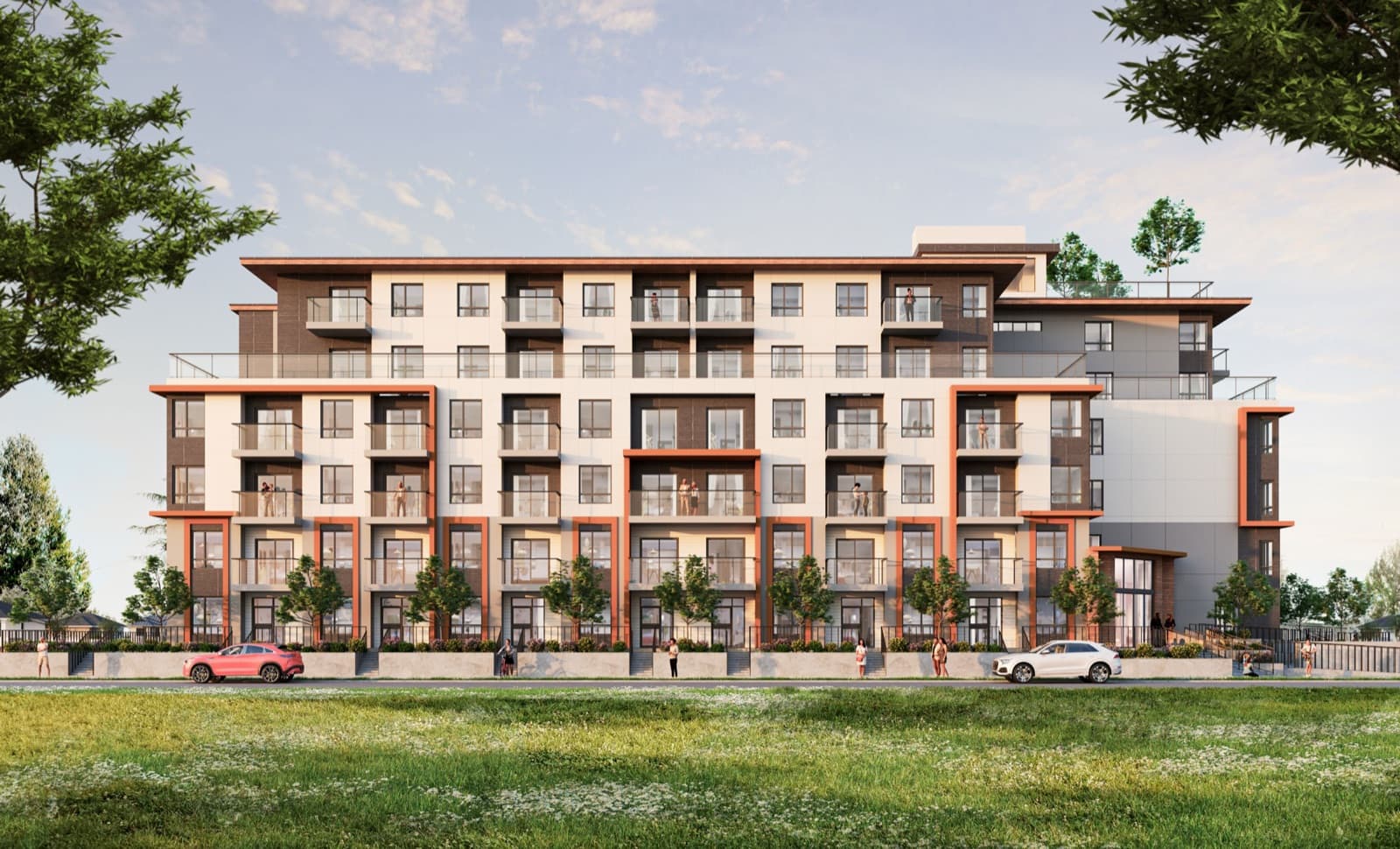Véra – A daytime street-level view of a mid-rise apartment building with cream, brown, and orange-accented facade and ground-floor townhome entries.