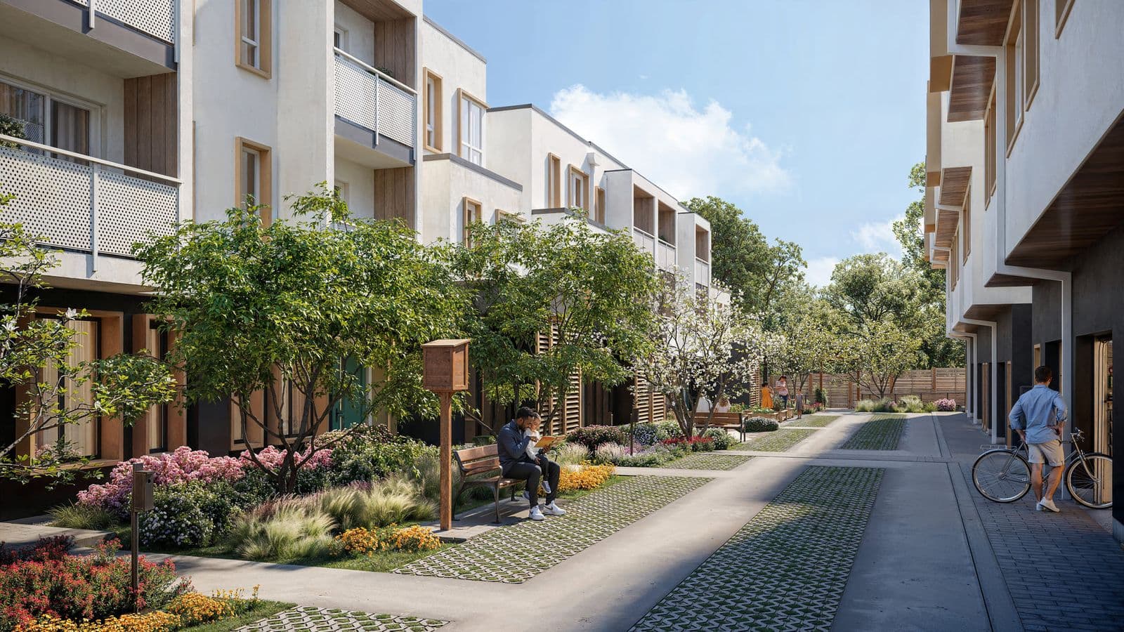 Oaklyn – A landscaped pedestrian walkway between rows of townhomes with flowering trees, benches, a little free library box, and residents walking and relaxing.