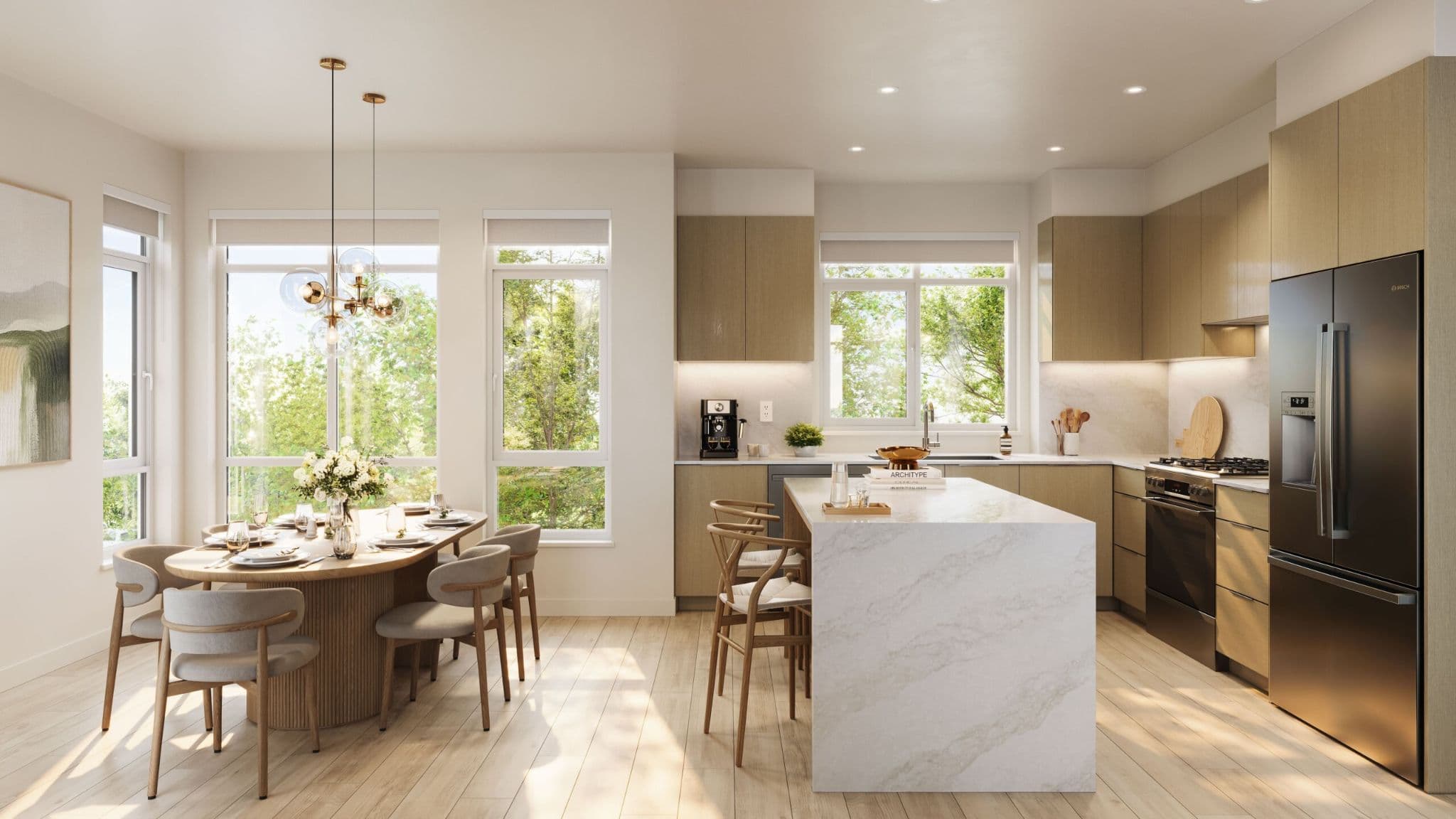 Quilchena West – Open-concept kitchen and dining area with a large marble waterfall island, wood cabinetry, stainless steel appliances, and a round dining table by large windows.