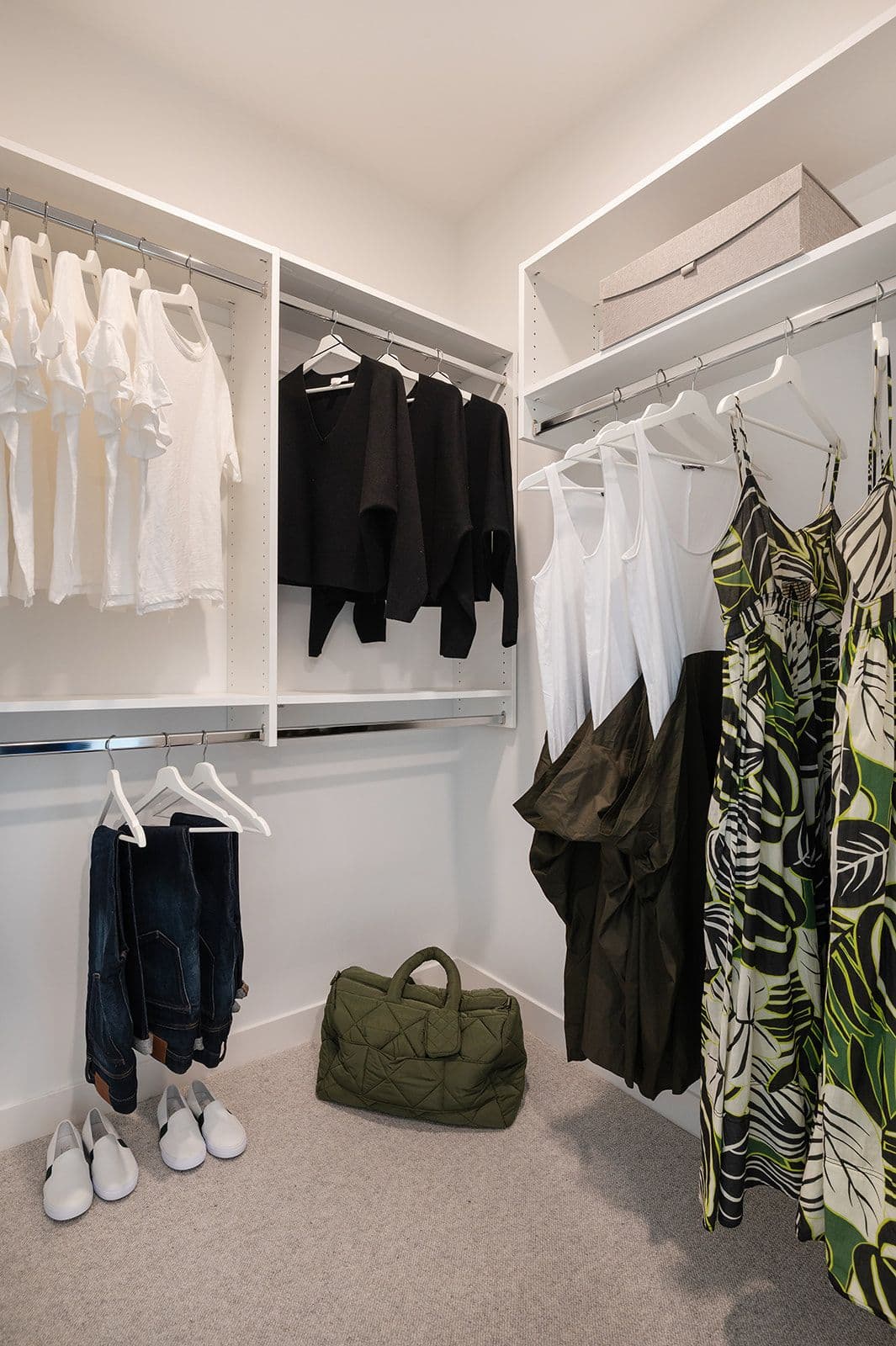Sundays on Grant – Walk-in closet organized with double hanging rods, white shelves, clothing on hangers, and shoes on carpeted floor.