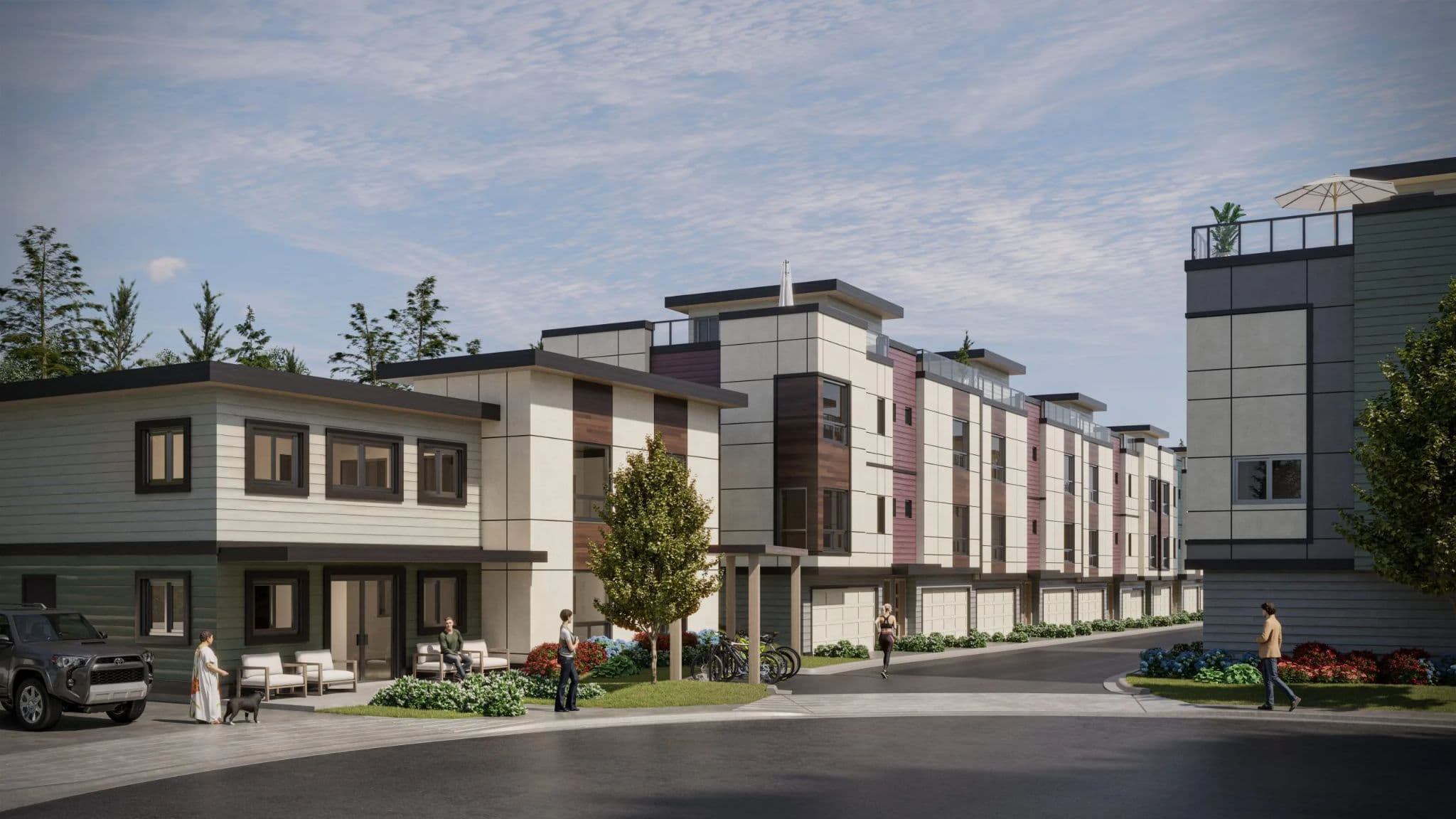 Skyview – A ground-level rendering of a modern townhome community featuring multi-toned panel facades, wood accents, ground-floor garages, and private rooftop decks under a bright daylight sky. Pedestrians walk along the paved inner driveway past landscaped shrubbery, parked bicycles, and a patio area with outdoor seating.