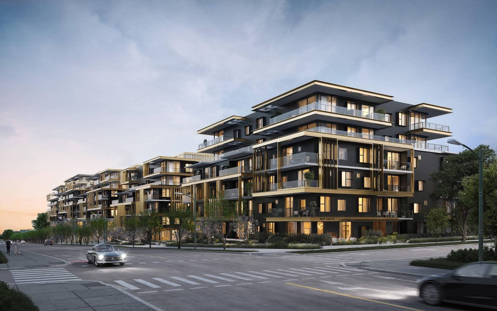 Fränk – A street-level architectural rendering of a multi-story modern residential complex featuring matte black facades with prominent metallic gold accents and warm interior lighting. The building fronts a clean city street with crosswalks, young trees, and cars driving past during dusk under a soft, overcast sky.