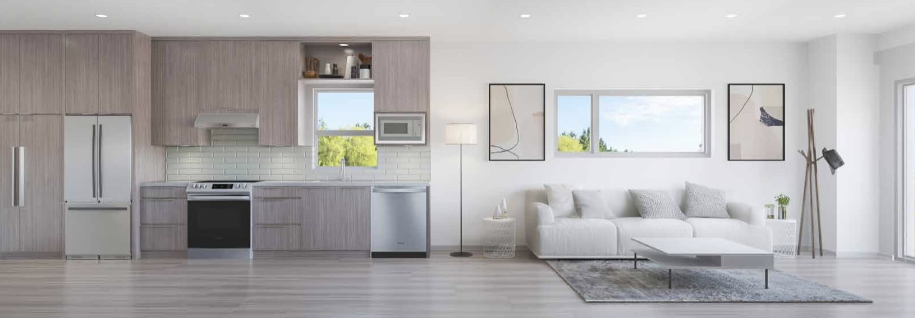 Twelve at Norquay Park – Open-concept kitchen and living room with grey wood cabinetry, stainless appliances, and a white sofa with framed art above it.