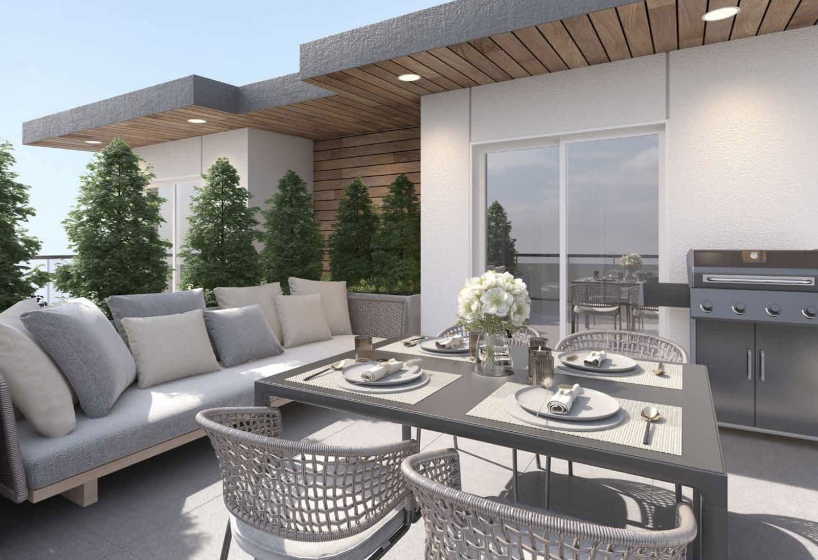 Twelve at Norquay Park – Rooftop outdoor dining and lounge area with a sectional sofa, dining table set for four, built-in barbecue, and cedar hedge screening.