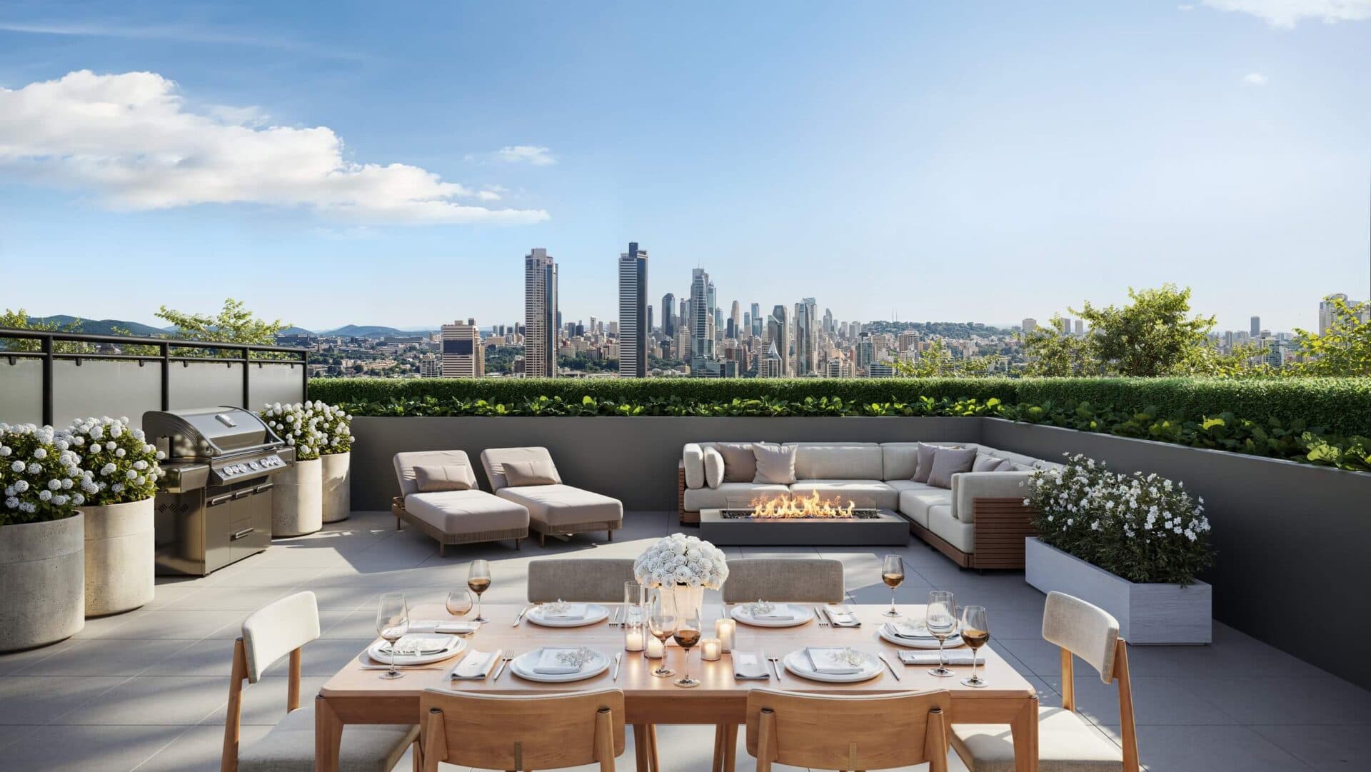 Centrale – A luxurious outdoor rooftop terrace features a set dining table in the foreground, a built-in BBQ, two lounge chairs, and an L-shaped sofa surrounding a fire pit. Greenery and planter boxes line the perimeter wall, framing a expansive view of a distant city skyline under a clear blue sky.