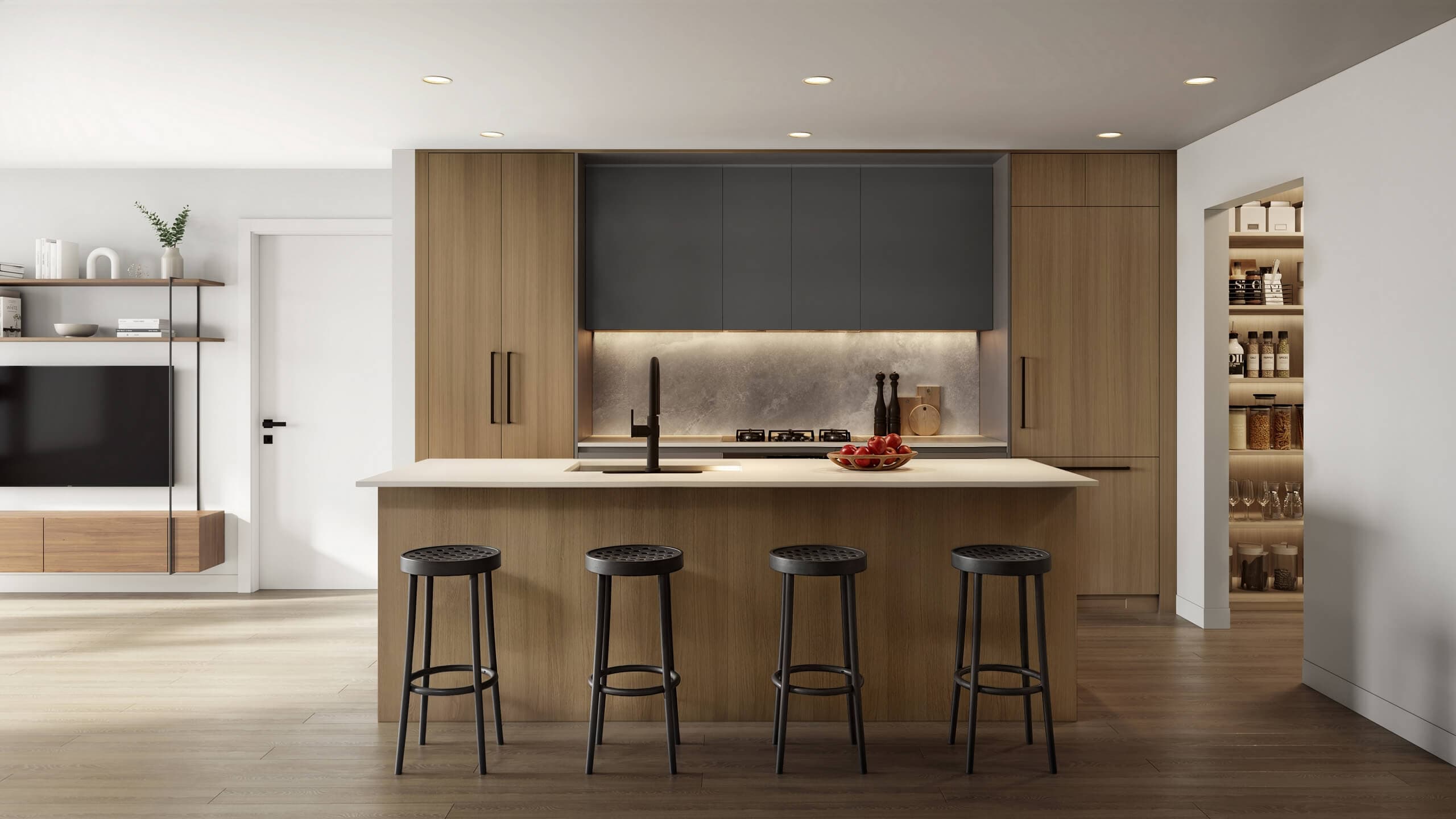 Centrale – A modern open-concept kitchen featuring light wood cabinetry, a matte black upper cabinet section, an illuminated stone backsplash, and a central island with four black barstools. The space connects seamlessly to an adjacent media unit on the left and a walk-in pantry with organized shelving on the right.