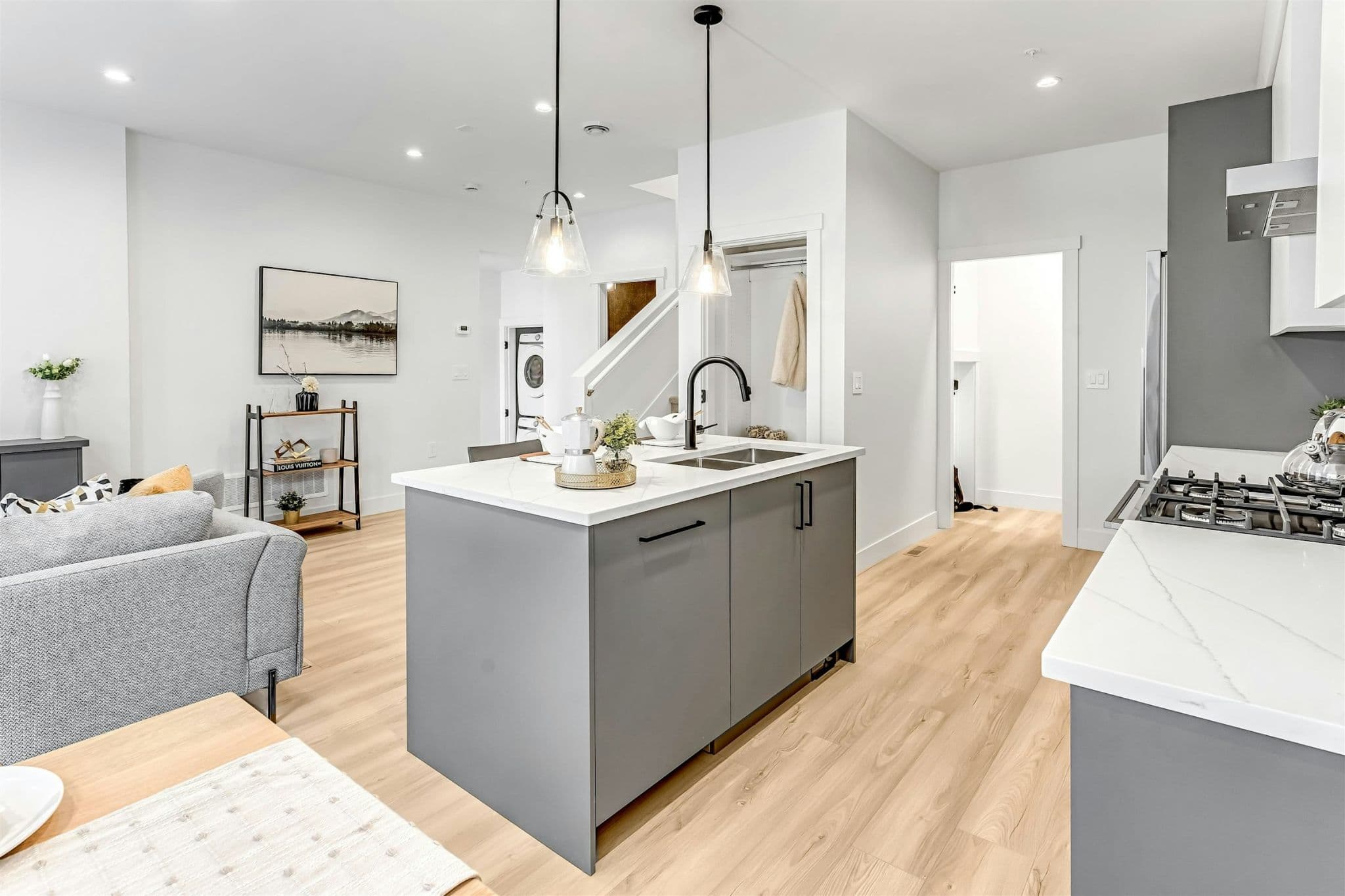 Park Avenue Townhomes – A bright kitchen layout showing the center island, gas cooktop counter, and open transition into the surrounding main living area.