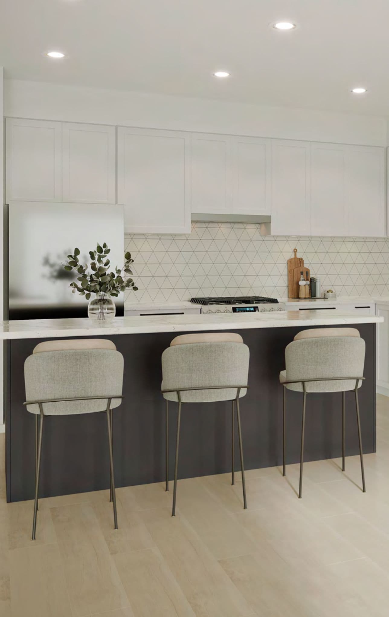JEM Condos – Kitchen with white cabinetry, a triangular tile backsplash, stainless refrigerator, and a dark waterfall island with three grey bar stools.