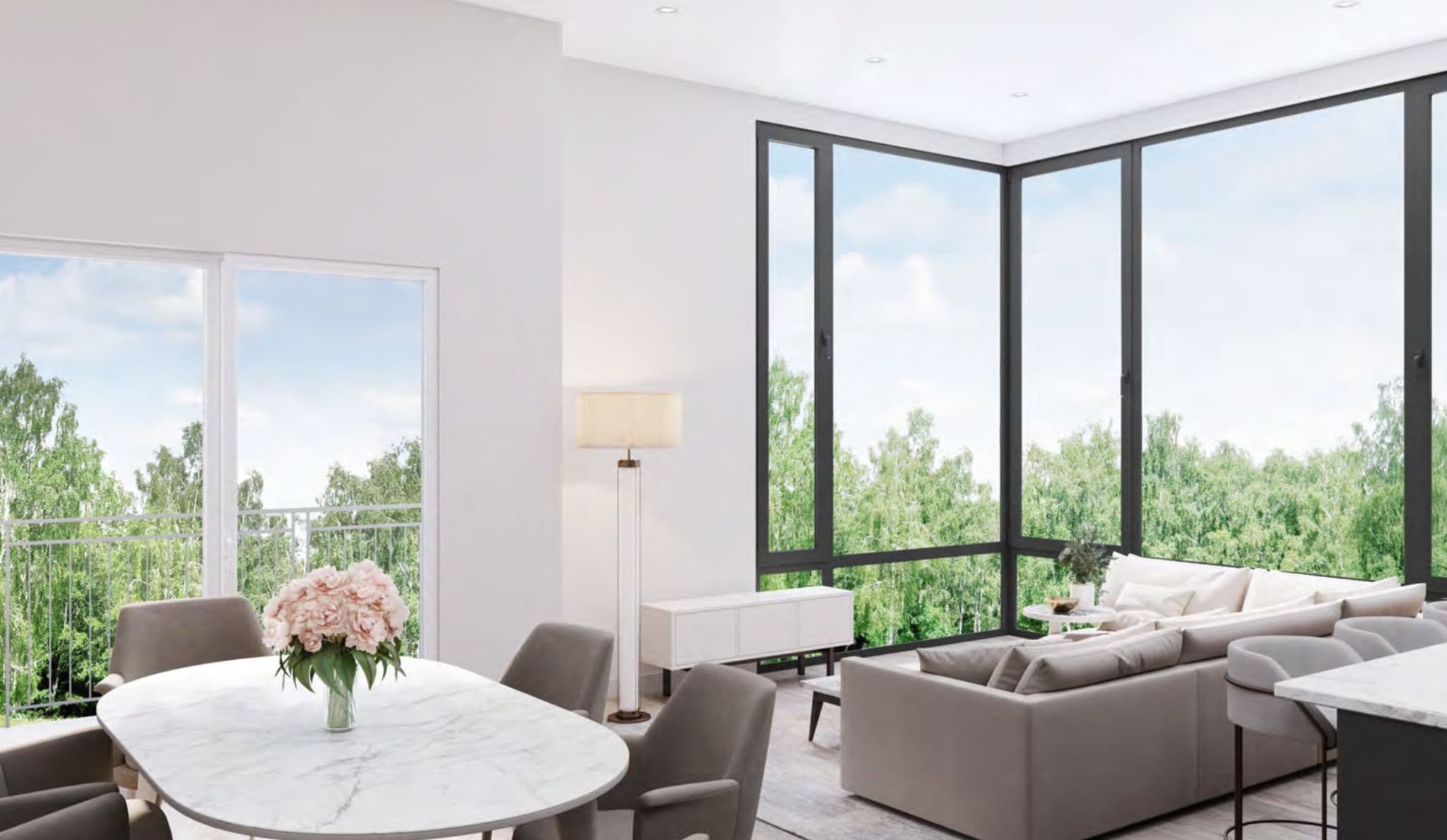 JEM Condos – Living and dining area with a large sectional sofa, round dining table set with flowers, and floor-to-ceiling corner windows overlooking treetops.