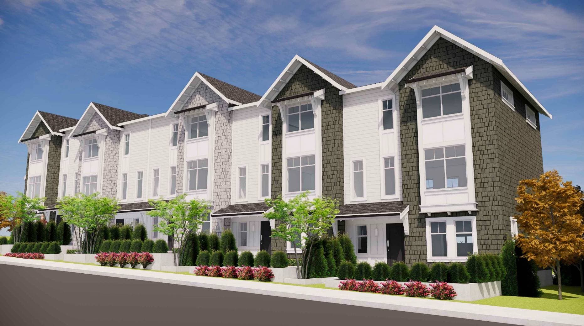 Ocean Park – A row of modern three-story townhomes featuring gabled rooflines, dark grey shake siding, and crisp white panel accents under a bright blue sky with light clouds. Landscaped front entryways line the sidewalk below, bordered by green shrubs, small trees, and pink flowering bushes.