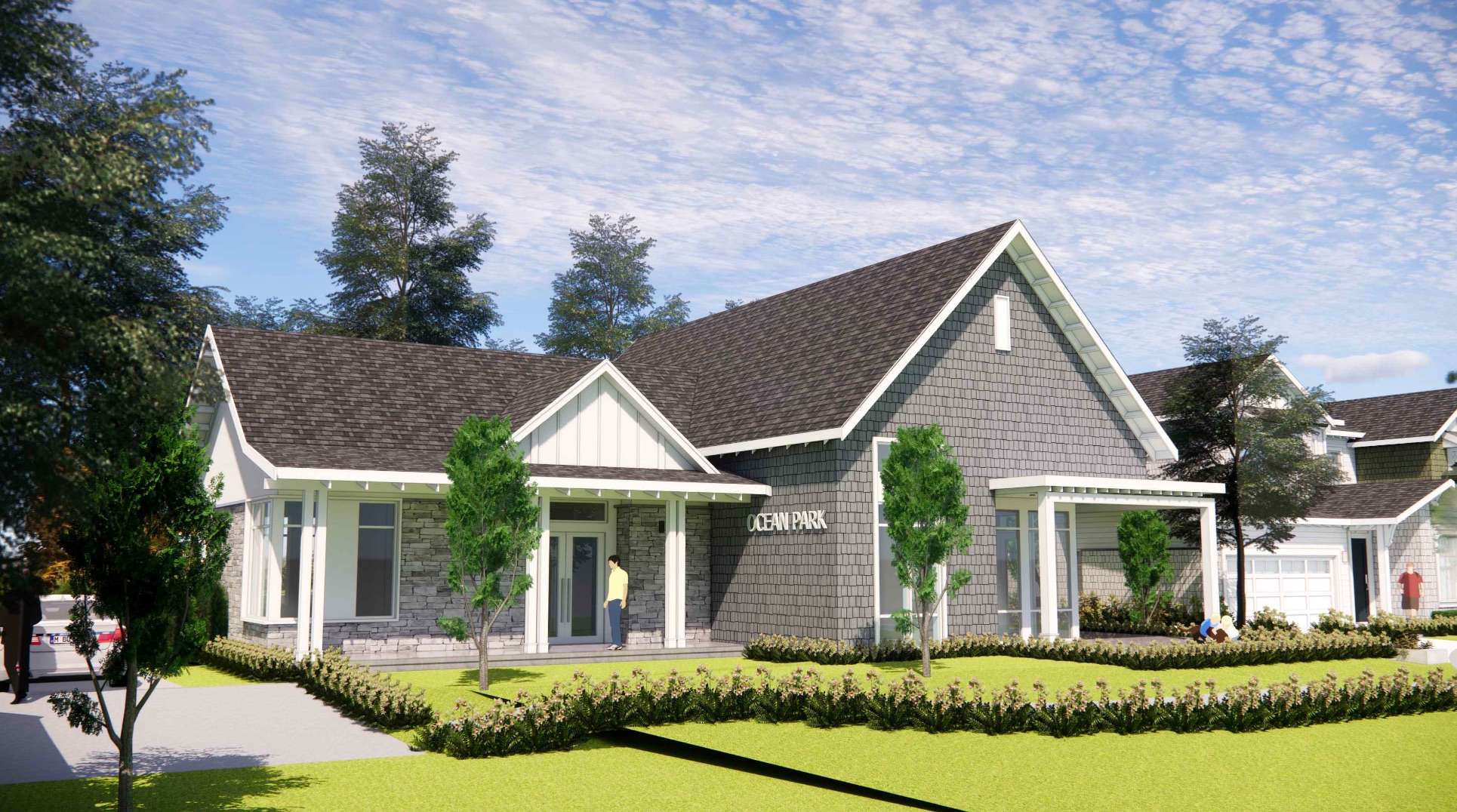 Ocean Park – A rendering of a single-story craftsman-style building featuring grey shingle siding, a stone facade accent, and white trim under a gabled roof. The property includes a manicured front lawn, low shrub hedges, young trees, and a bright blue sky with light clouds overhead.
