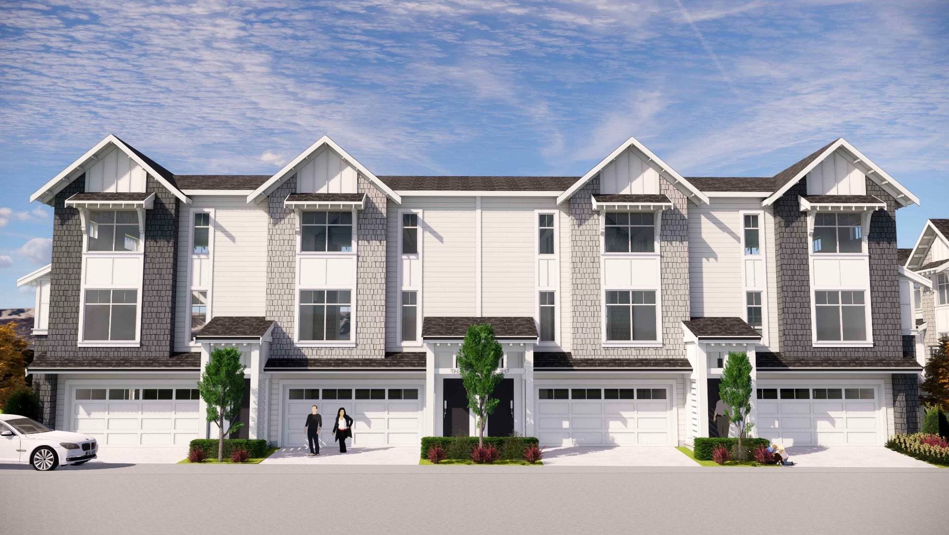Ocean Park – A straight-on rendering of a three-story townhome complex featuring gabled roofs, dark and light shingle accents, white siding, and attached ground-floor garages. Small green trees, landscaping bushes, and rendered figures of people are positioned along the paved driveway under a bright blue sky with light clouds.