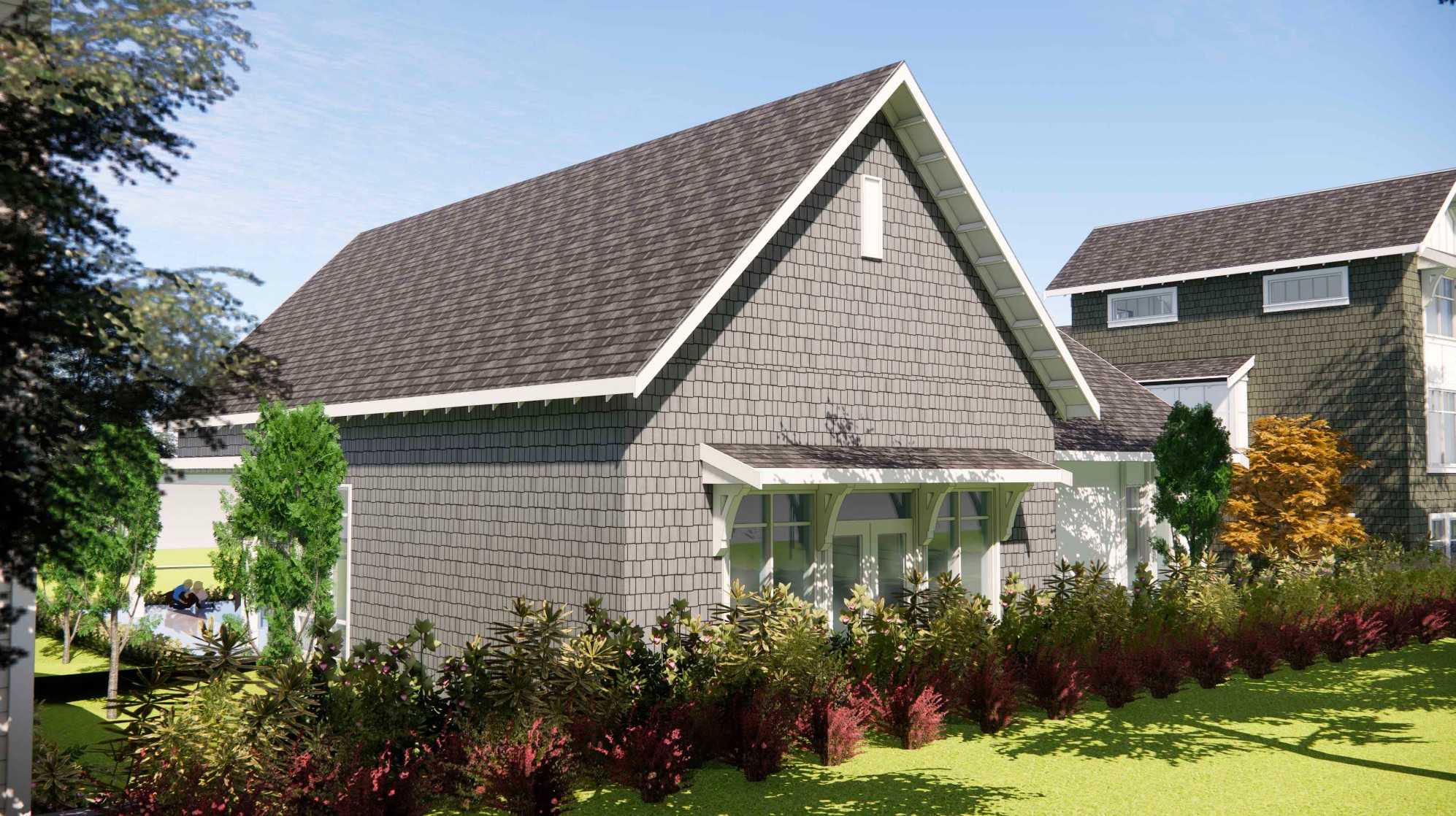 Ocean Park – A modern craftsman-style home featuring grey shingle siding, a steep pitched roof with dark shingles, and white trim accents. Lush green lawns, vibrant shrubs, and manicured landscaping surround the structure under a clear, bright daylight sky.