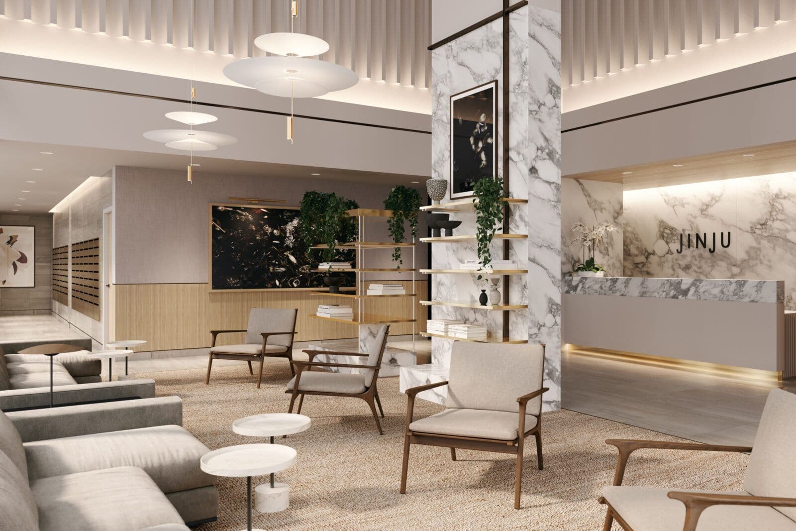 Jinju – A bright and elegant residential lobby and lounge area furnished with modern armchairs, plush sofas, and small marble side tables set over a textured rug. High ceilings with vertical slat detailing, hanging disc-shaped pendant lights, and a marble-clad concierge desk under the sign 'JINJU' create an upscale, welcoming atmosphere.