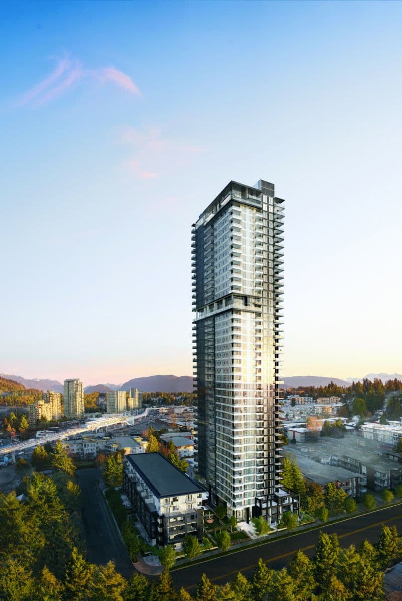 Jinju – Aerial dusk view of a tall high-rise tower with surrounding low-rise buildings, roads, and mountains in the distance.