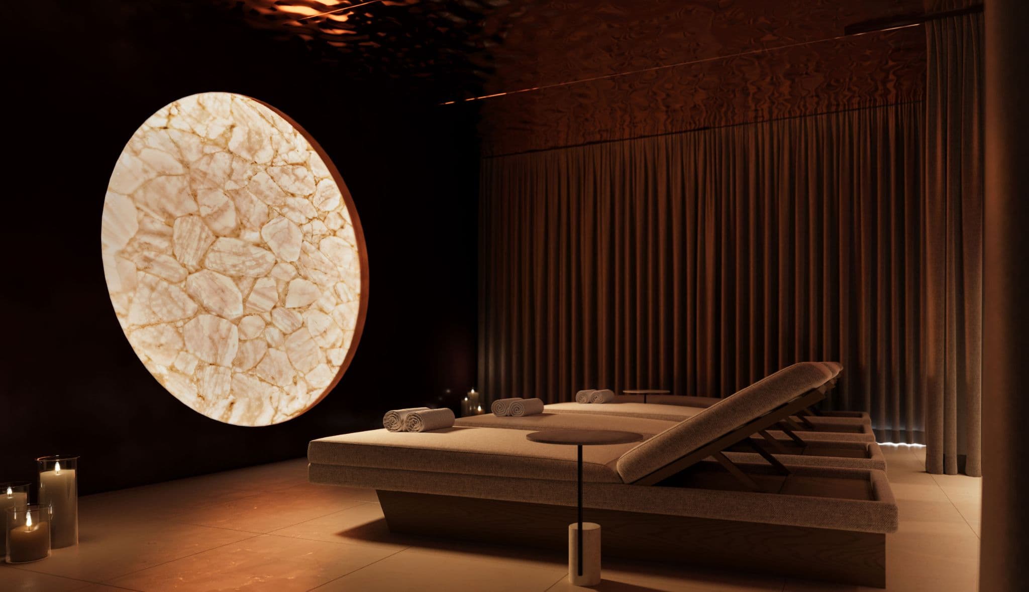 Kwasen Village – Dim, candlelit spa relaxation lounge with wood lounge chairs, rolled towels, a large illuminated round crystal-stone art piece, and floor-to-ceiling curtains.