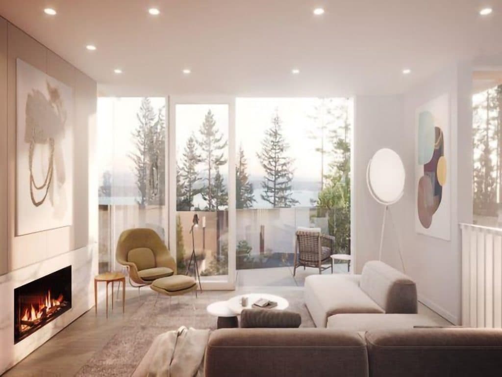 Alpine – Living room with a fireplace, lounge chairs, and floor-to-ceiling glass doors opening onto a deck with a water view.