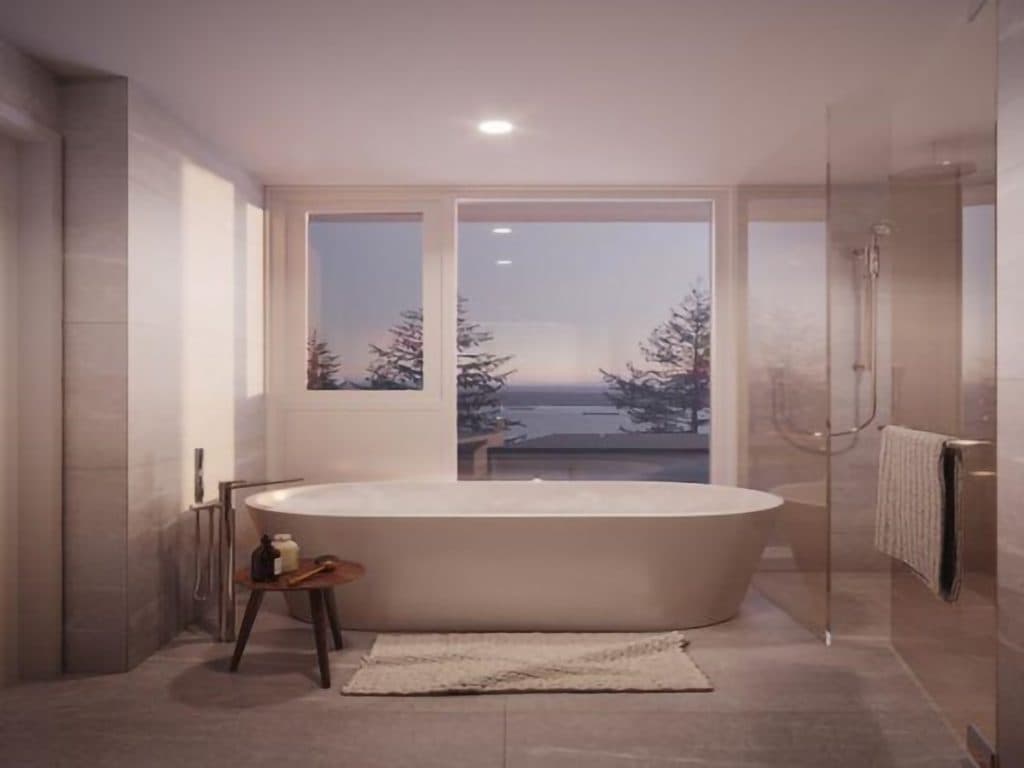 Alpine – Bathroom with a freestanding soaking tub in front of a large window with a water view, plus a glass-enclosed shower.