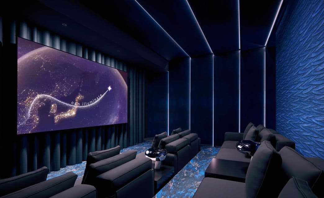 Gryphon Nova Condos – A rendering of a private home theatre with dark tufted reclining seating and a large screen showing a nighttime map graphic.