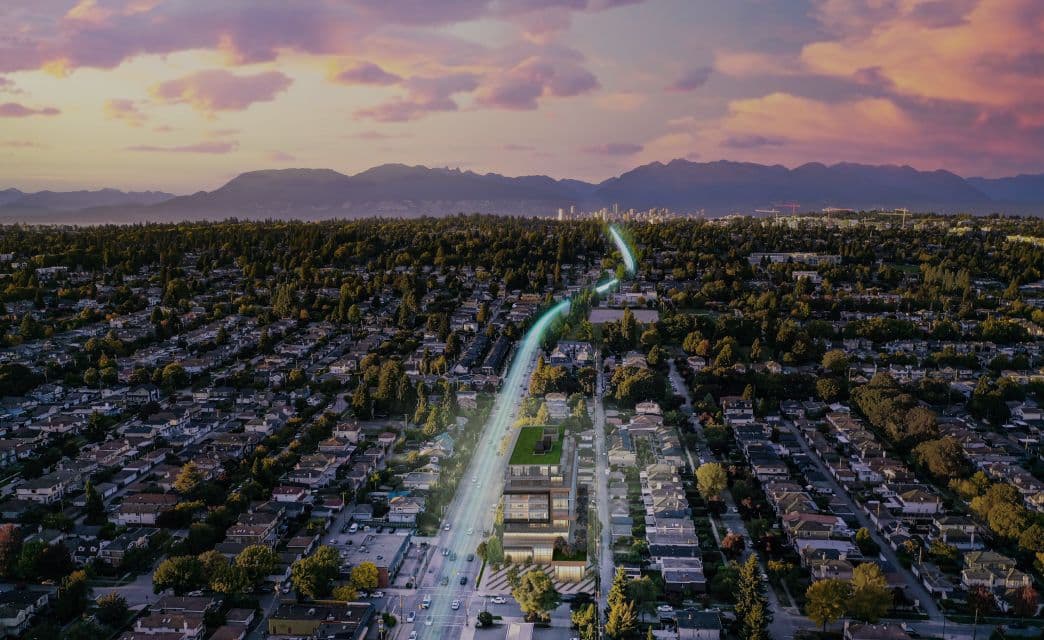 Gryphon Nova Condos – An aerial rendering at dusk showing the building rising above a grid of residential streets with mountains and a downtown skyline in the background.