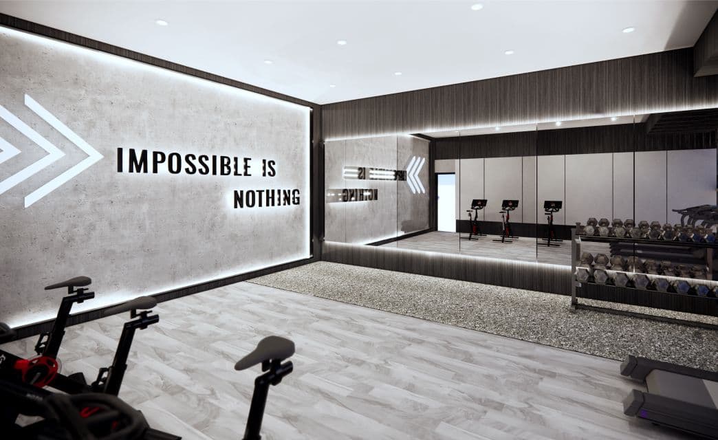Gryphon Nova Condos – A rendering of a fitness studio with spin bikes, a mirrored wall reading 'Impossible Is Nothing,' and a weight rack in the background.