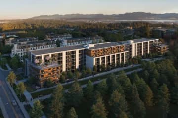 Azure Grove – Drone shot of a mid-rise residential complex surrounded by trees, with mountains visible in the distance.