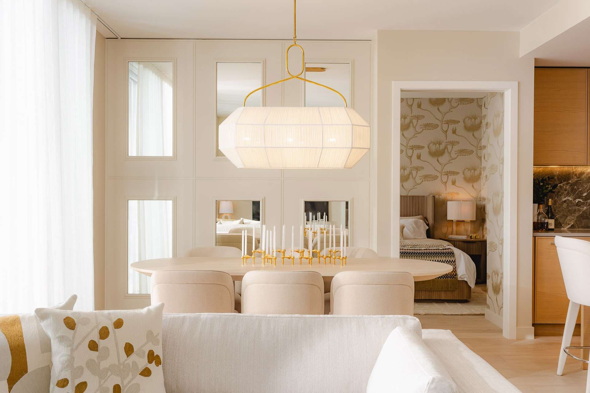 Rockford – Dining area with a round table and pendant light, opening into a bedroom with patterned bedding.