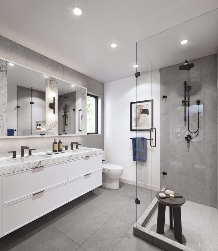 Whitford – A modern residential bathroom featuring a double floating vanity with white marble countertops, white cabinetry, and sleek matte black hardware. Large grey floor and wall tiles complement the framed glass walk-in shower, which is equipped with a black rain showerhead and handheld fixture.