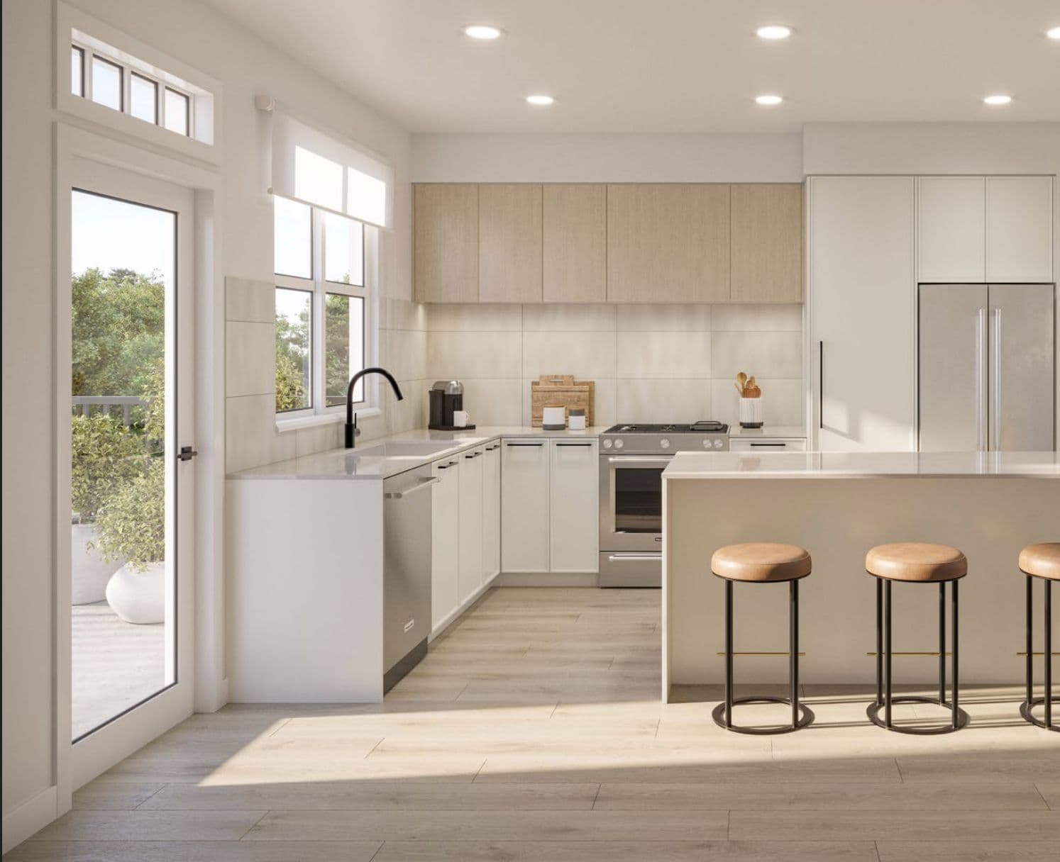 Queenston Towns – Kitchen with light wood upper cabinets, white lower cabinets, an island with stools, and a door to a patio.