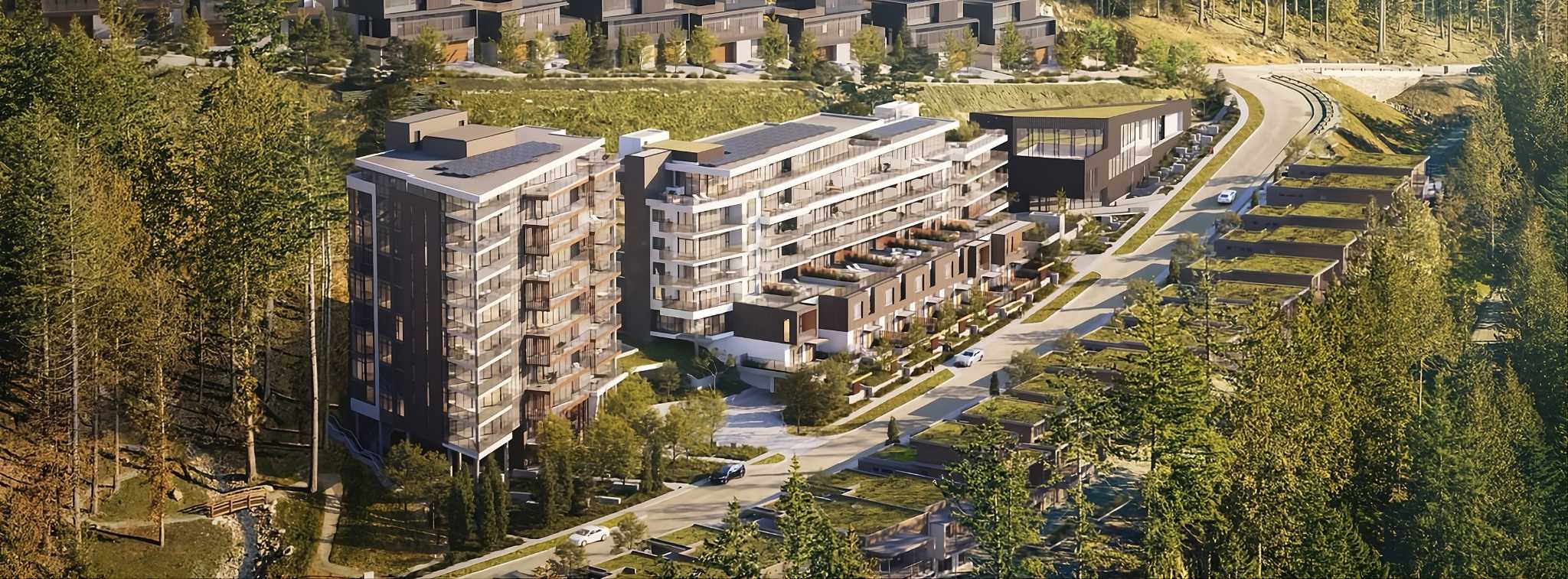 Hawksley – An elevated rendering showcases a hillside residential development featuring modern mid-rise condominium buildings and green-roofed townhomes along a curved mountain road. Dense pine forests border the complex, which is illuminated by warm, late-afternoon sunlight.