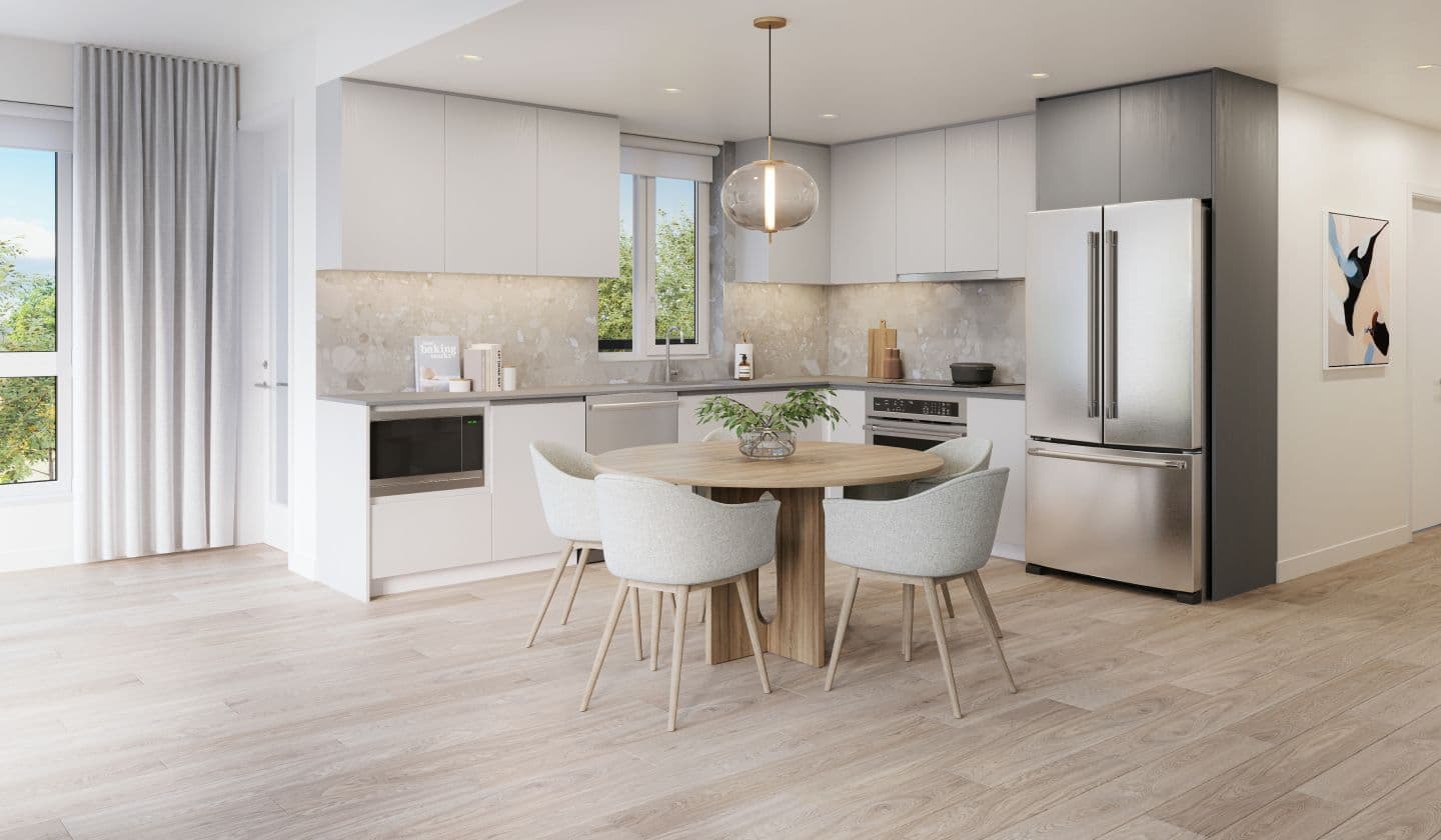 Marlow – An open kitchen and dining area with grey cabinetry, a stainless fridge, pendant light, and a round wood dining table with upholstered chairs.
