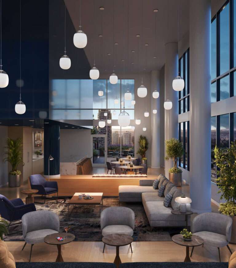 Juno Condos – Sky lounge at dusk with clustered pendant lights, a linear fireplace, sectional seating and floor-to-ceiling windows overlooking the city skyline.