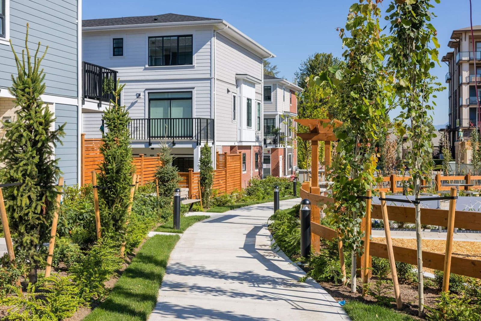 Townside Village – Photo of a landscaped walking path through the townhome development with newly planted trees and garden beds.