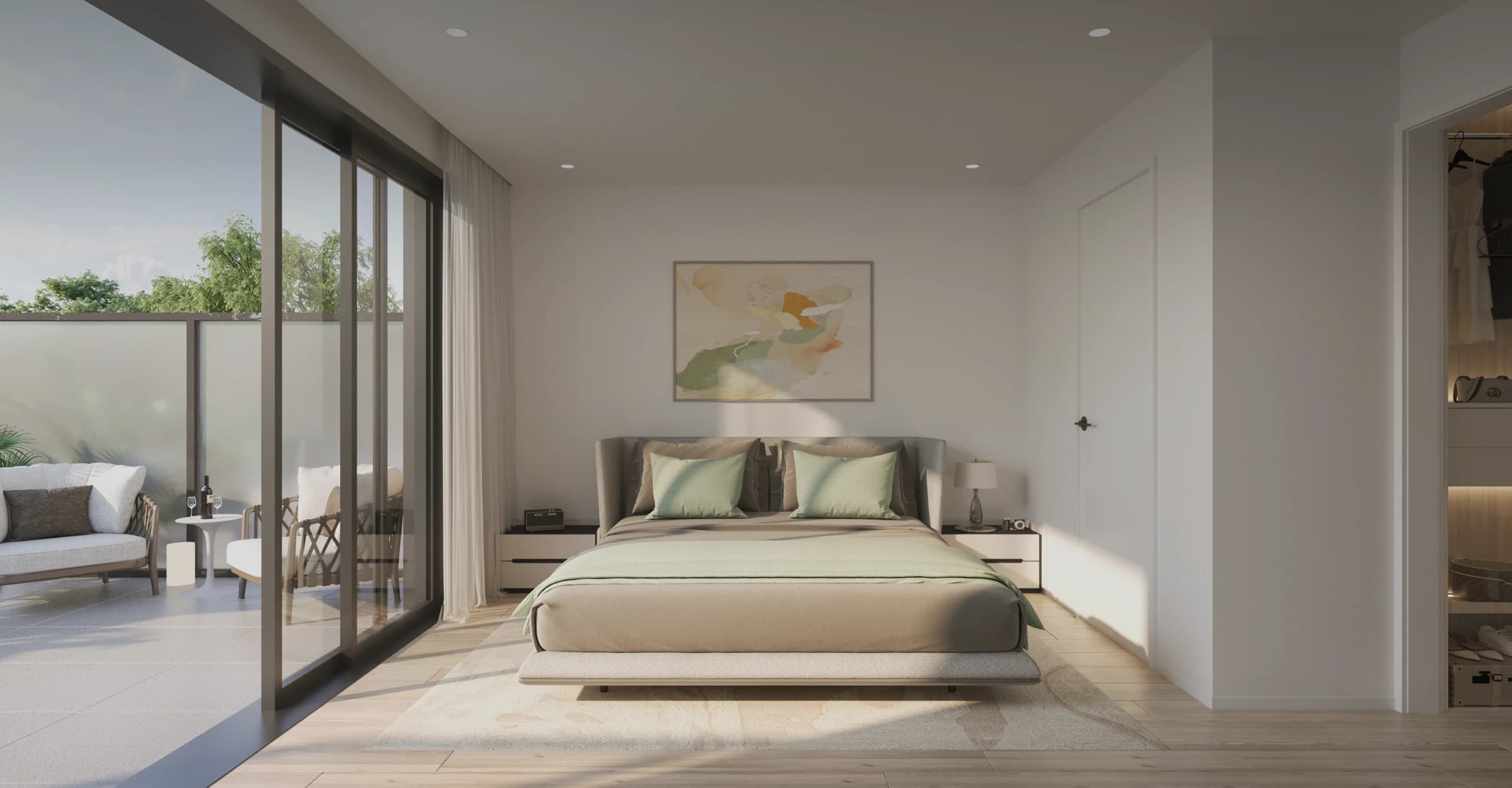 Emera – A modern, bright bedroom features a made bed with muted green and beige bedding, flanked by nightstands and an abstract artwork on the main white wall. Large glass sliding doors open to an outdoor patio furnished with armchairs, while natural sunlight streams into the room across light wood flooring.