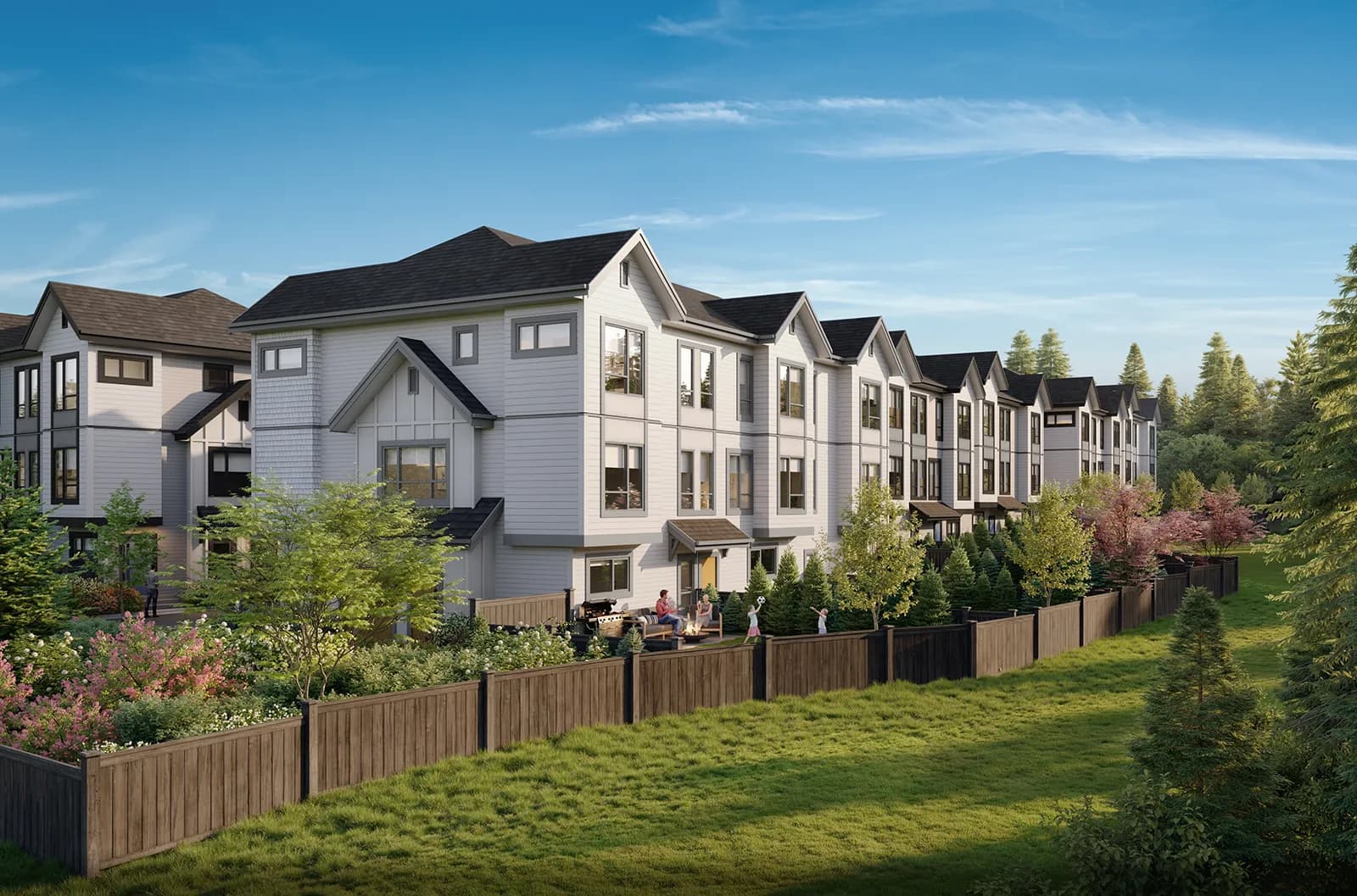 Nature Haus – Backyard-facing view of a row of townhomes with wood fencing, where a family grills and relaxes on a patio with children playing on the lawn.