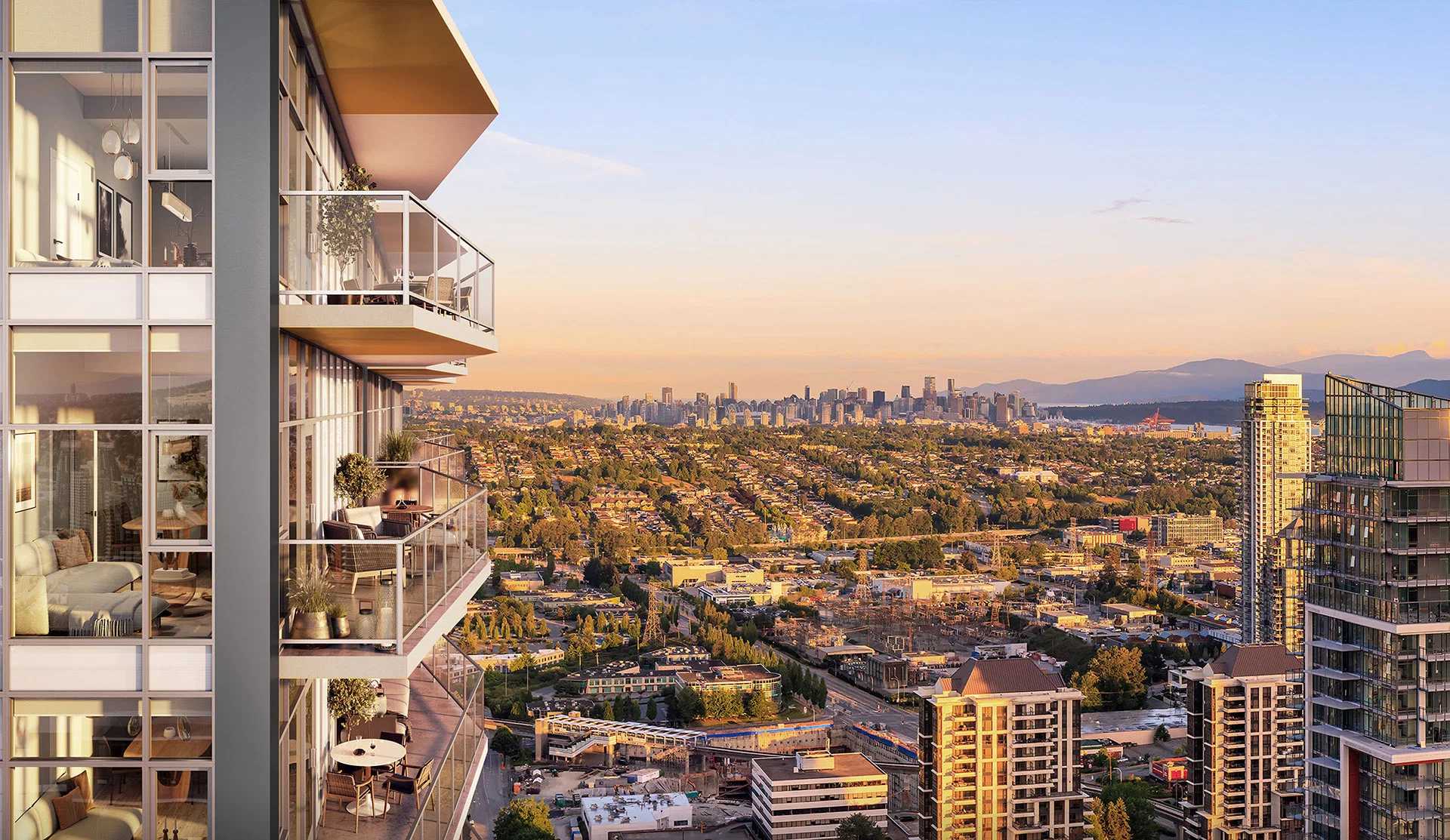 South Yards – View from a high-floor balcony looking out over a suburban landscape toward a distant downtown skyline and mountains at sunset, with the neighboring tower's balconies visible alongside.