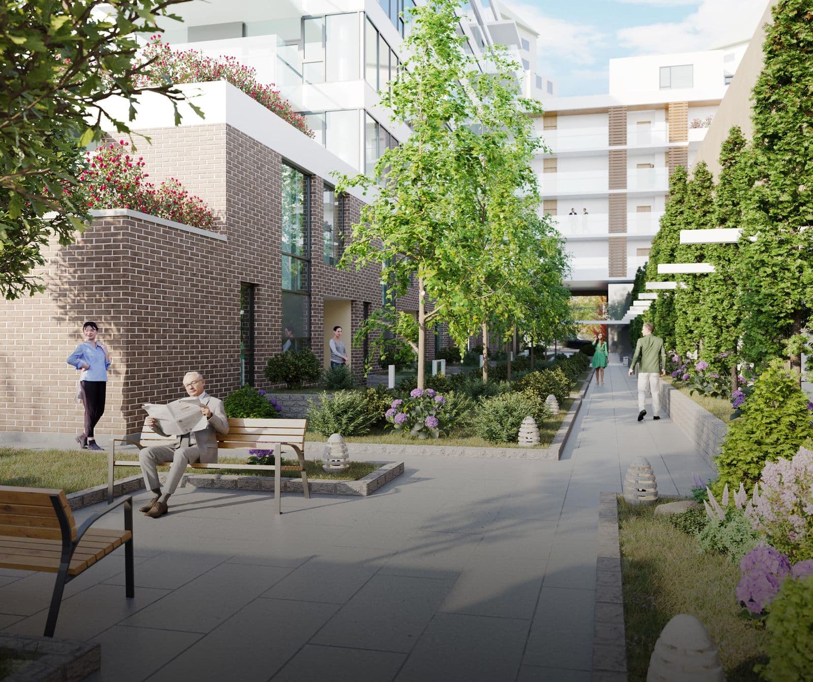 Executive on the Park – Landscaped courtyard walkway between brick residential buildings with benches, flowering shrubs, and people walking and reading.