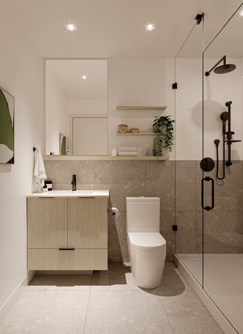 Baden Park – Bathroom with a wood vanity, large mirror, toilet, and glass-enclosed rain shower with dark matte fixtures.