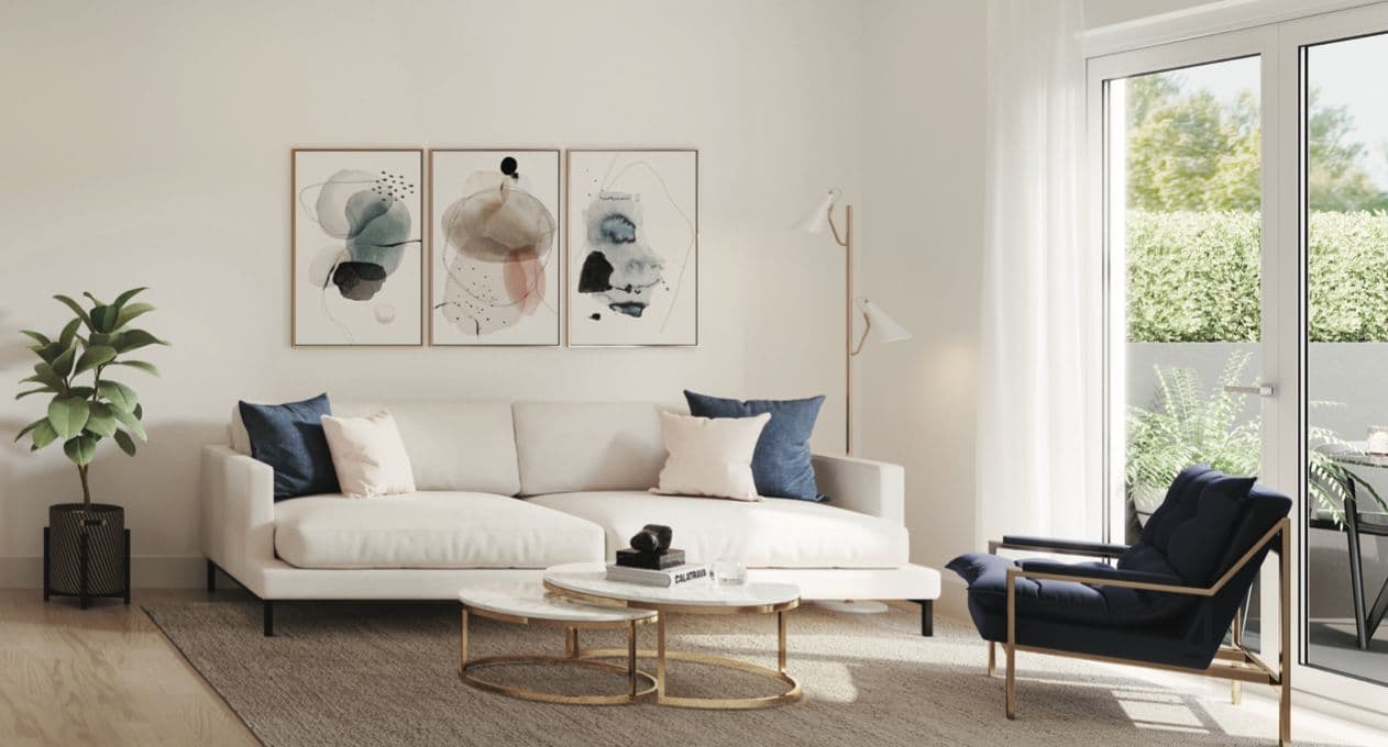Lakewood – A living room with a white sofa, framed abstract art, a navy accent chair, and a glass door leading to a small patio with greenery.