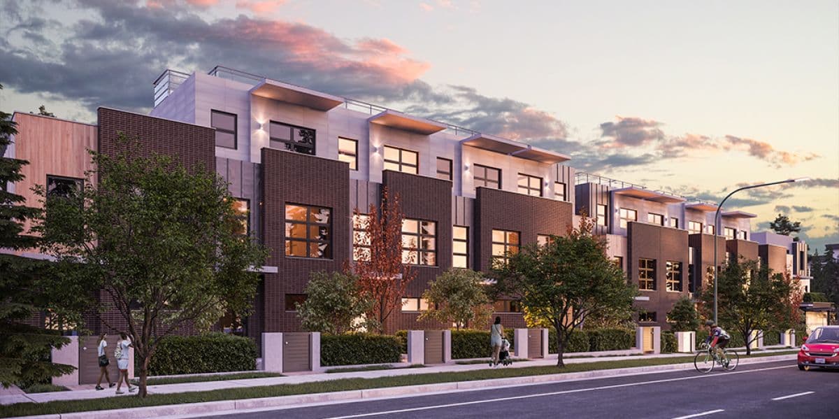 27North – Twilight street-level view of brick-clad townhomes with people walking and biking past.