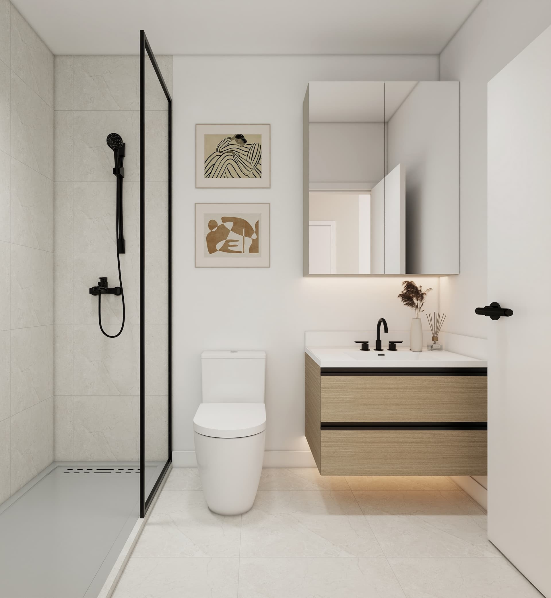 Kamilia – A modern, minimalist bathroom featuring a floating light-wood vanity with under-cabinet lighting, a white porcelain toilet, and a walk-in shower with a black-framed glass partition. Matte black hardware and fixtures contrast cleanly with the white walls, framed abstract prints, and light marble-look tiled flooring and shower walls.