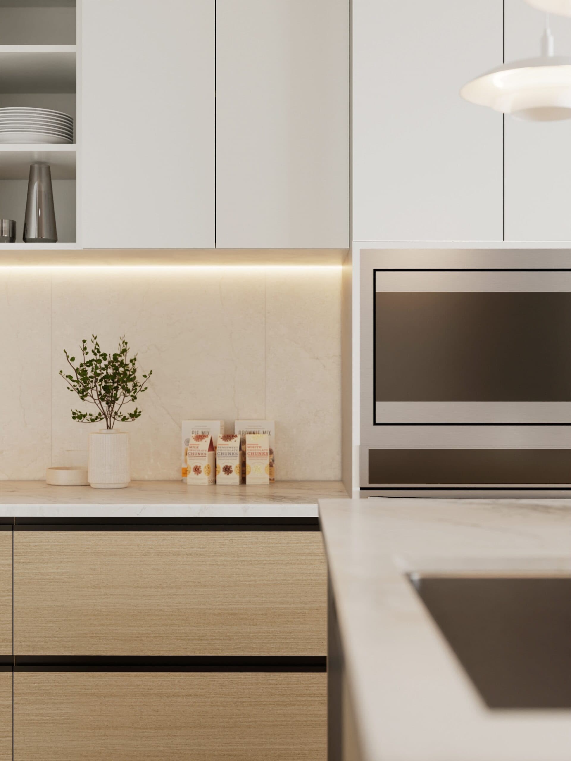Kamilia – A modern kitchen detail shot showing light wood lower cabinetry, flat-panel white upper cabinets, and a built-in stainless steel wall oven. Warm under-cabinet LED strip lighting illuminates a marble-patterned backsplash decorated with a small potted plant and boxed goods.