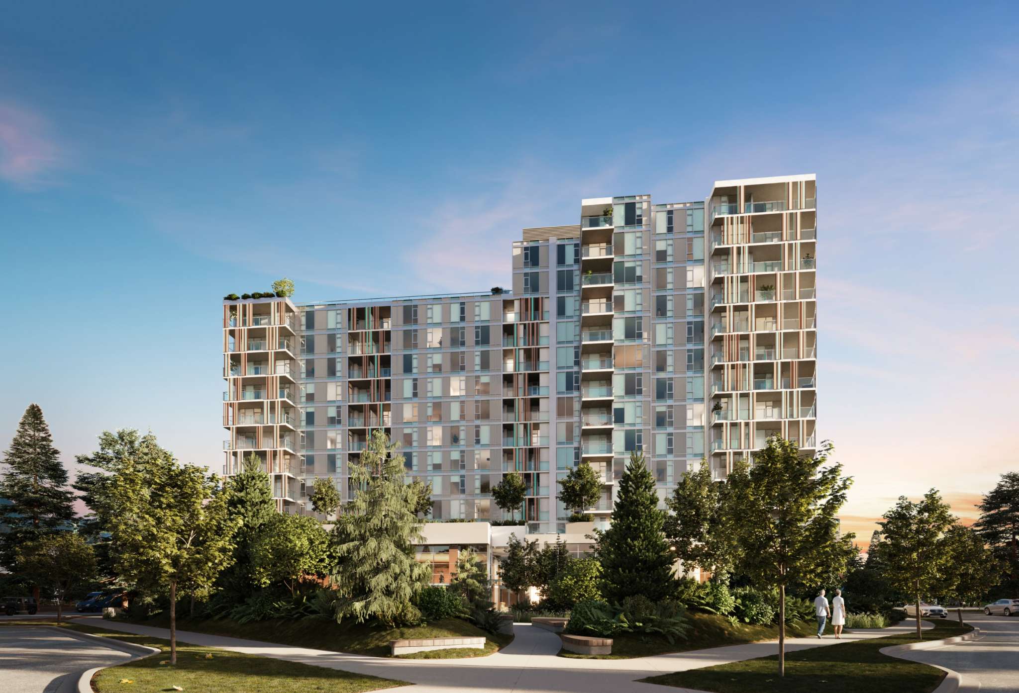 Talistar – A modern mid-rise residential building with a stepped facade features floor-to-ceiling windows and private balconies framed by vertical decorative accents. Lush green parkland, mature trees, and paved walking paths line the foreground under a clear, bright sky at dusk.