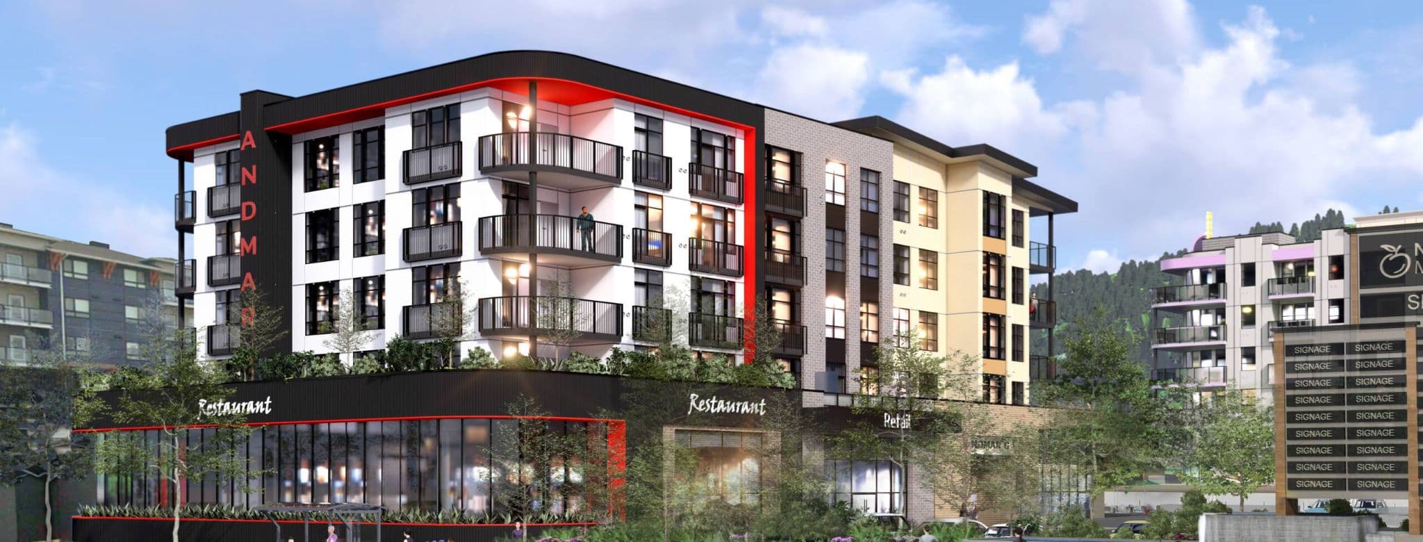 Andmar 3 – An architectural rendering of a multi-story mixed-use building featuring ground-floor restaurant and retail storefronts beneath several levels of residential units. The exterior combines black, white, and tan siding accented by a vibrant red trim and framed corner balconies against a backdrop of forested hills under a partly cloudy sky.
