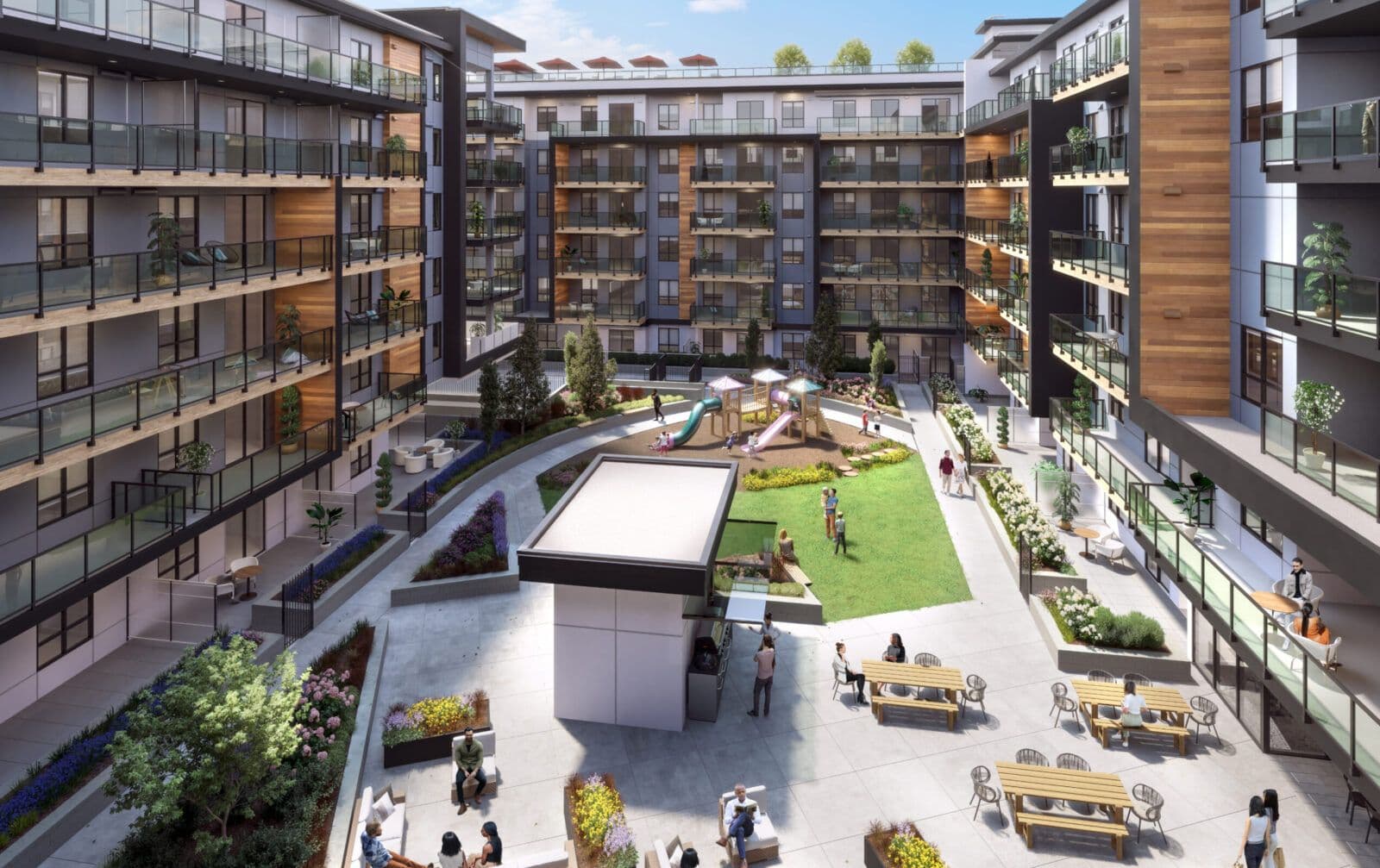 Scott + 77 – An elevated view showcases a modern residential courtyard enclosed by multi-story apartment buildings with glass balconies and wood-accent siding. The outdoor amenity space features a central green lawn, a children's playground, landscaped garden beds, and multiple seating areas with picnic tables and lounge chairs on a paved patio during a bright day.